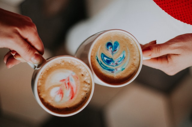 hands holding cups of coffee